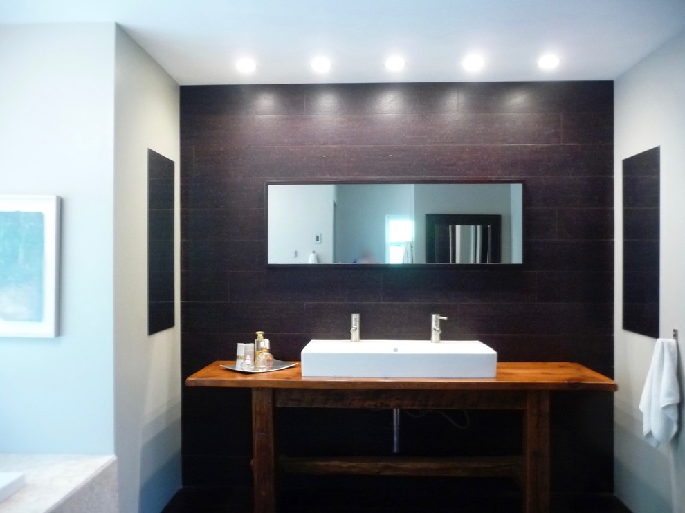 Mittelgroßes Modernes Badezimmer En Suite mit Einbaubadewanne, Doppeldusche, Wandtoilette mit Spülkasten, brauner Wandfarbe, Korkboden, Aufsatzwaschbecken, Waschtisch aus Holz, braunem Boden und Falttür-Duschabtrennung in New York