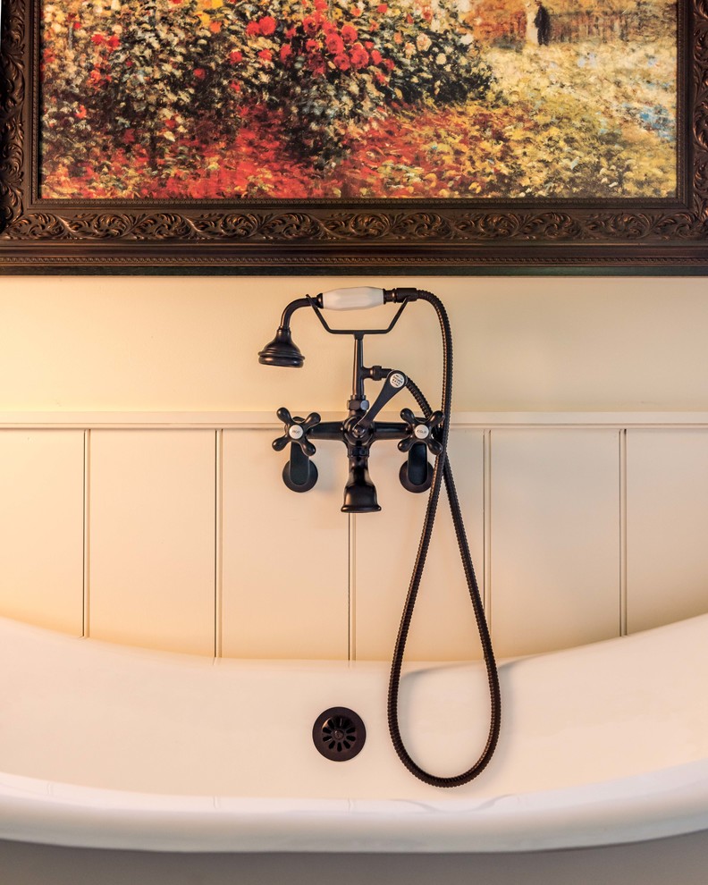 This is an example of a traditional ensuite bathroom in Philadelphia with a claw-foot bath, white walls and dark hardwood flooring.