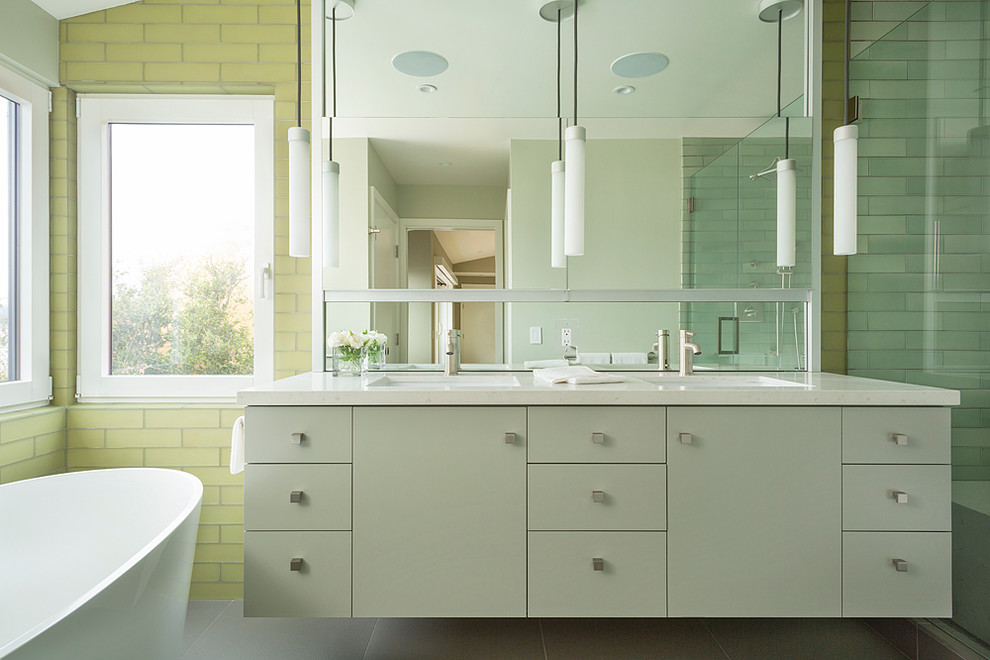 This is an example of a contemporary bathroom in San Francisco with a submerged sink, flat-panel cabinets, grey cabinets, a freestanding bath, yellow tiles and glass tiles.