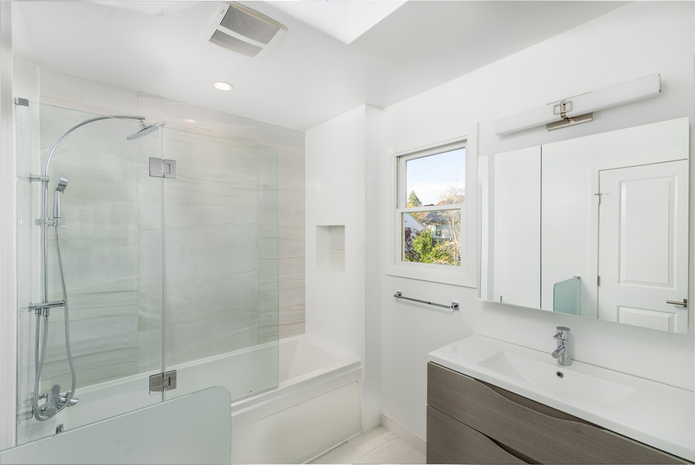 Double shower - mid-sized contemporary master white tile and porcelain tile porcelain tile double shower idea in New York with furniture-like cabinets, white cabinets, a one-piece toilet, white walls, an integrated sink and limestone countertops