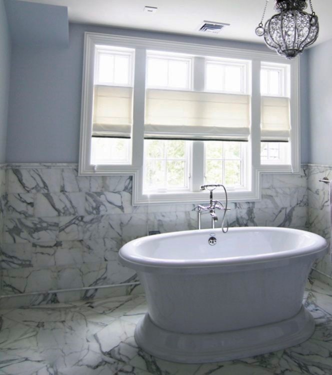 Aménagement d'une très grande salle de bain principale classique en bois brun avec un placard à porte shaker, un plan de toilette en granite, une baignoire sur pieds, un mur bleu et un sol en marbre.