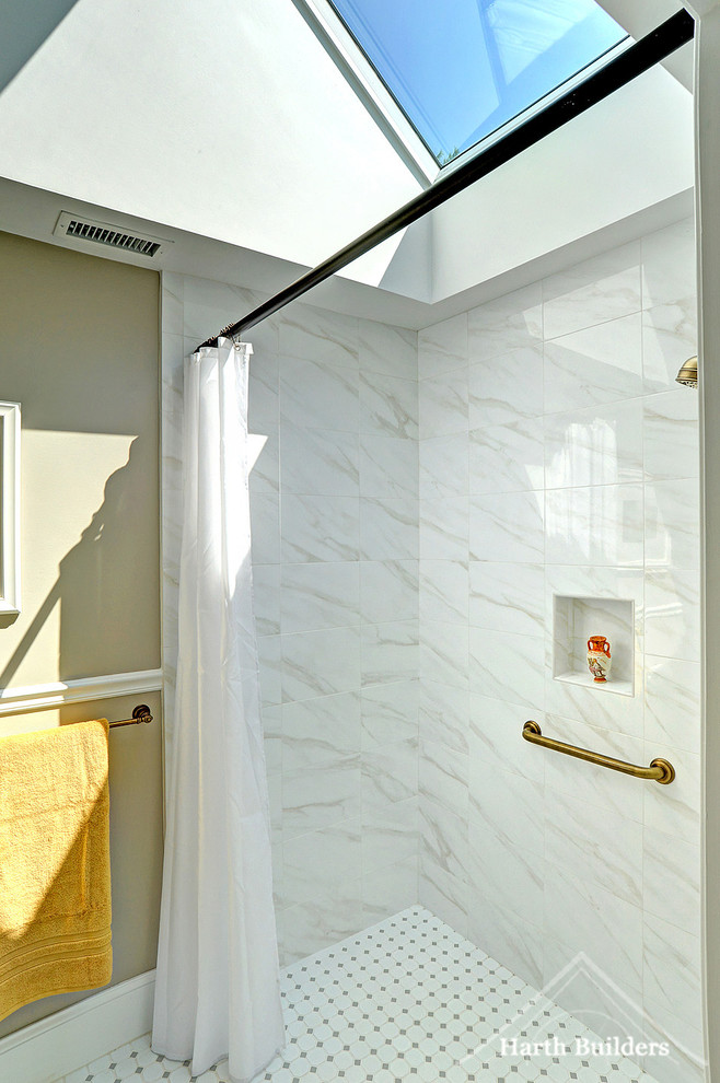 Inredning av ett klassiskt mellanstort badrum, med en kantlös dusch, en toalettstol med separat cisternkåpa, grå kakel, porslinskakel, grå väggar, klinkergolv i porslin och ett väggmonterat handfat