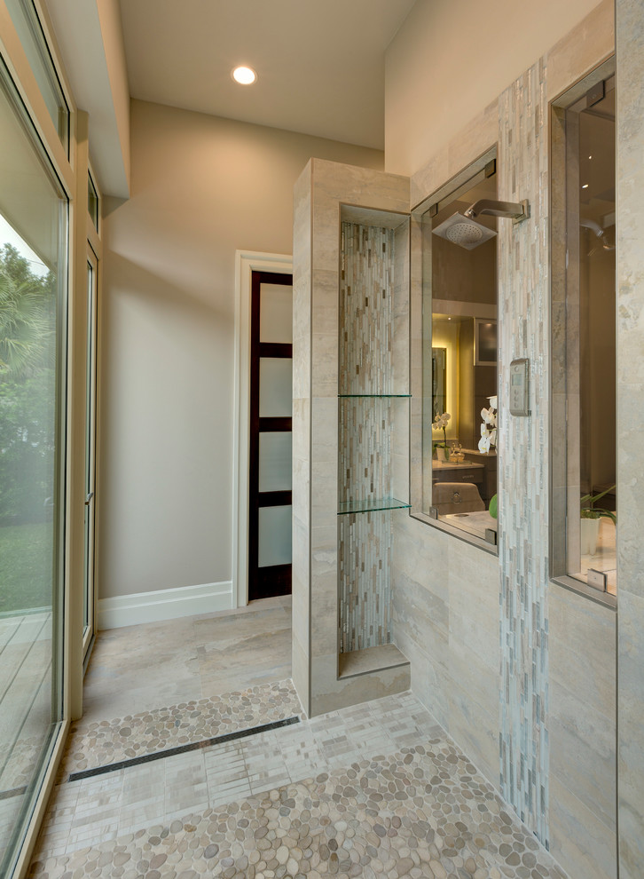 Cette image montre une salle de bain design avec une douche ouverte, un carrelage beige, un sol en galet, aucune cabine et une fenêtre.