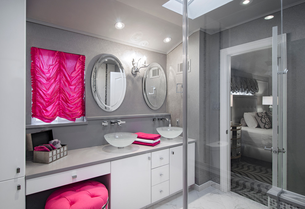 This is an example of a medium sized contemporary grey and pink ensuite bathroom in New York with a vessel sink, flat-panel cabinets, white cabinets, grey tiles, white tiles, grey walls, marble flooring, solid surface worktops, a corner shower, stone tiles, white floors, a hinged door and grey worktops.