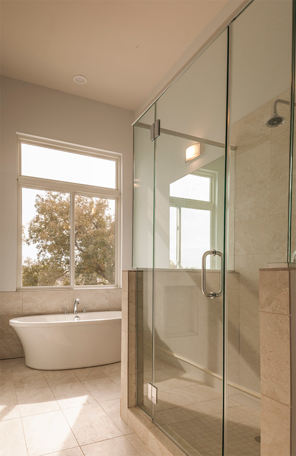 Cette image montre une grande salle de bain principale design avec une baignoire indépendante, WC à poser, un carrelage beige, des carreaux de porcelaine, un mur beige, un sol en carrelage de porcelaine et un plan de toilette en carrelage.
