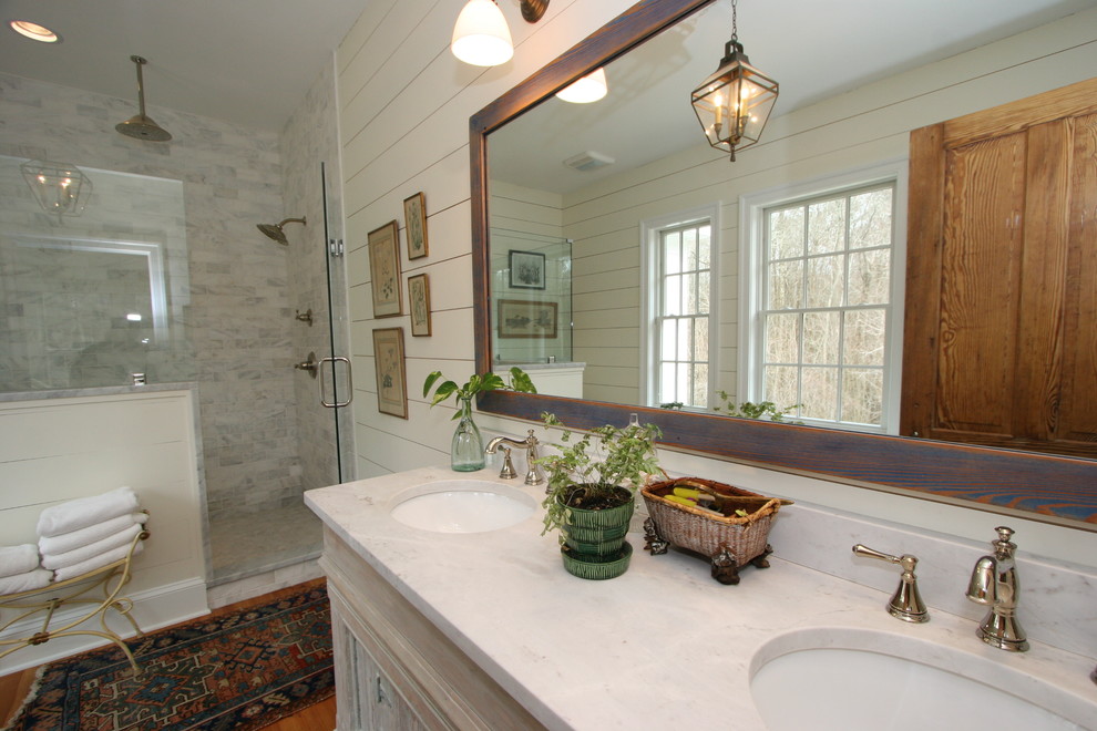 Exempel på ett mellanstort lantligt en-suite badrum, med luckor med upphöjd panel, ett badkar med tassar, en toalettstol med separat cisternkåpa, beige väggar, ett undermonterad handfat och marmorbänkskiva