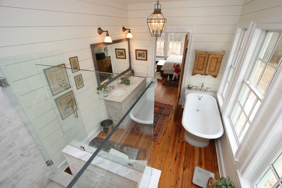 Inspiration for a mid-sized farmhouse master stone tile dark wood floor bathroom remodel in Baltimore with a two-piece toilet, beige walls, an undermount sink, marble countertops, raised-panel cabinets and gray cabinets