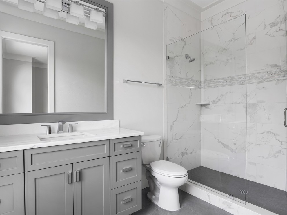 Свежая идея для дизайна: главная ванная комната среднего размера в стиле неоклассика (современная классика) с фасадами в стиле шейкер, серыми фасадами, полновстраиваемой ванной, душем в нише, раздельным унитазом, белой плиткой, мраморной плиткой, белыми стенами, врезной раковиной, мраморной столешницей, серым полом и душем с распашными дверями - отличное фото интерьера