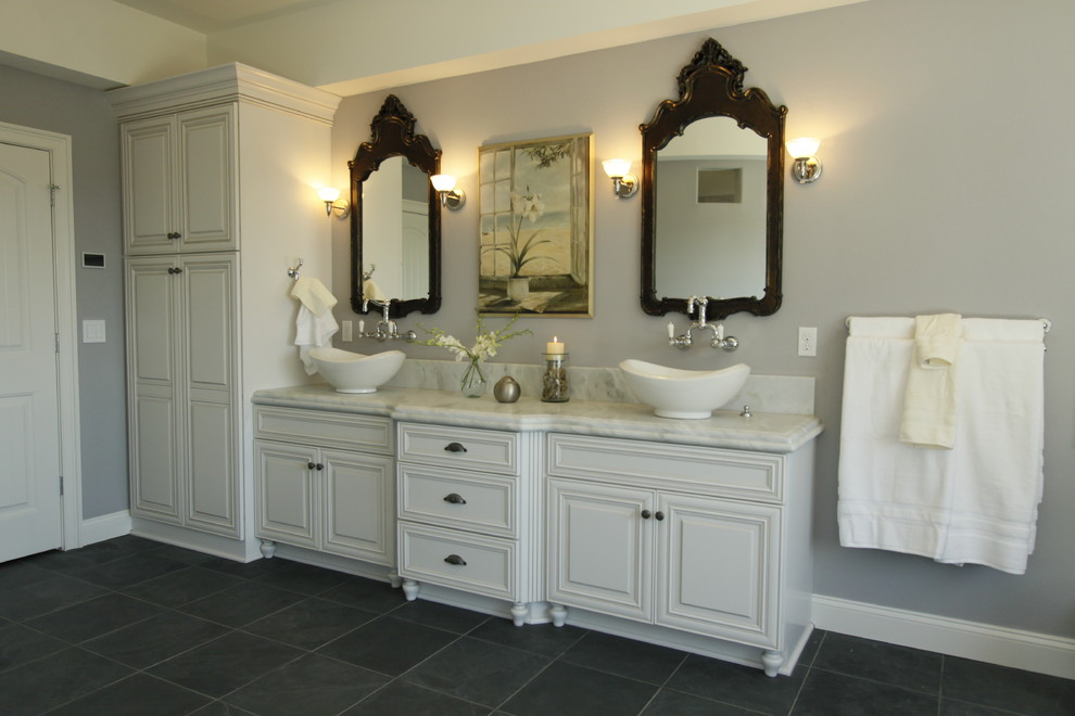 Aménagement d'une salle de bain montagne avec un carrelage multicolore, des portes de placard blanches, une douche ouverte, un mur bleu, un sol en bois brun et un plan de toilette en marbre.