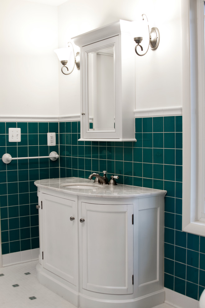 1950s white tile and ceramic tile bathroom photo in DC Metro with an undermount sink, raised-panel cabinets, white cabinets, marble countertops and a one-piece toilet