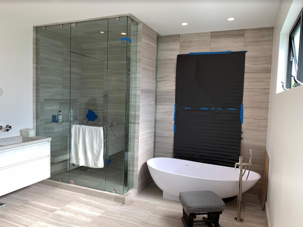 This is an example of a medium sized modern bathroom in Los Angeles with beige walls, bamboo flooring, a built-in sink, solid surface worktops and beige worktops.
