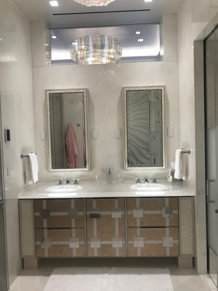 Design ideas for a medium sized contemporary ensuite bathroom in New York with freestanding cabinets, brown cabinets, a corner bath, a built-in shower, a one-piece toilet, beige tiles, marble tiles, beige walls, marble flooring, a vessel sink, glass worktops, beige floors, a hinged door and white worktops.