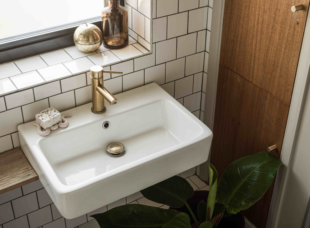 Inredning av ett minimalistiskt litet badrum med dusch, med vit kakel, keramikplattor och träbänkskiva