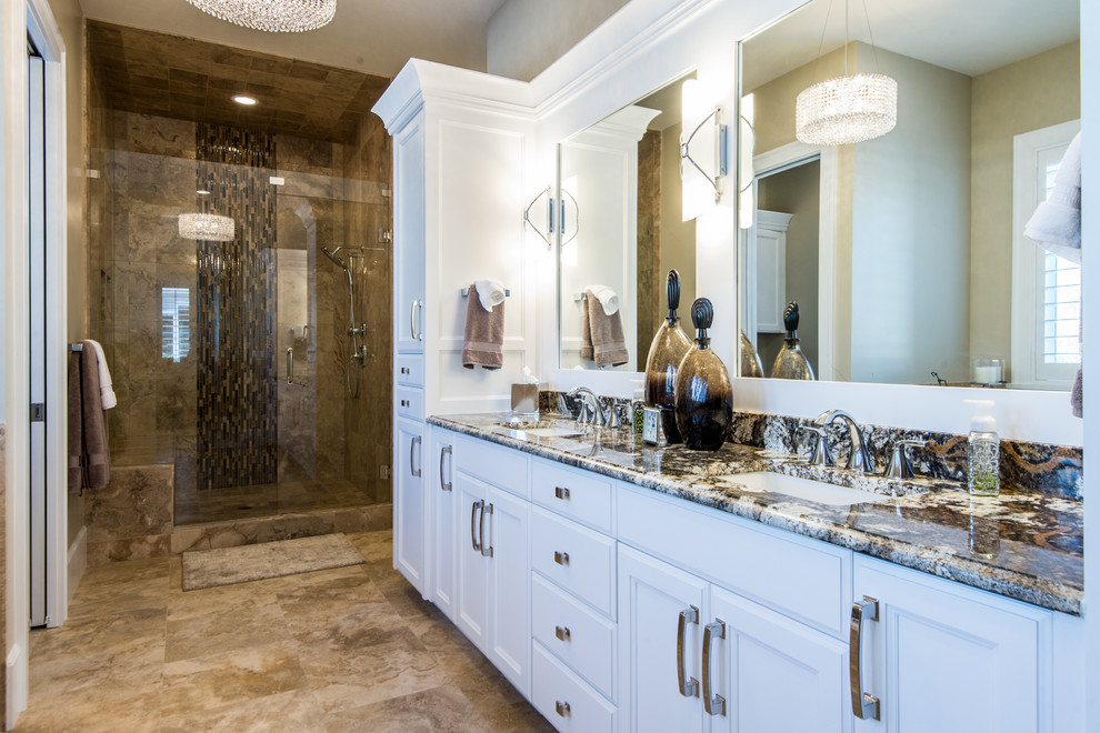 Inspiration for a medium sized traditional ensuite bathroom in Salt Lake City with raised-panel cabinets, white cabinets, a built-in bath, a built-in shower, a one-piece toilet, beige tiles, stone tiles, beige walls, travertine flooring, a submerged sink and granite worktops.