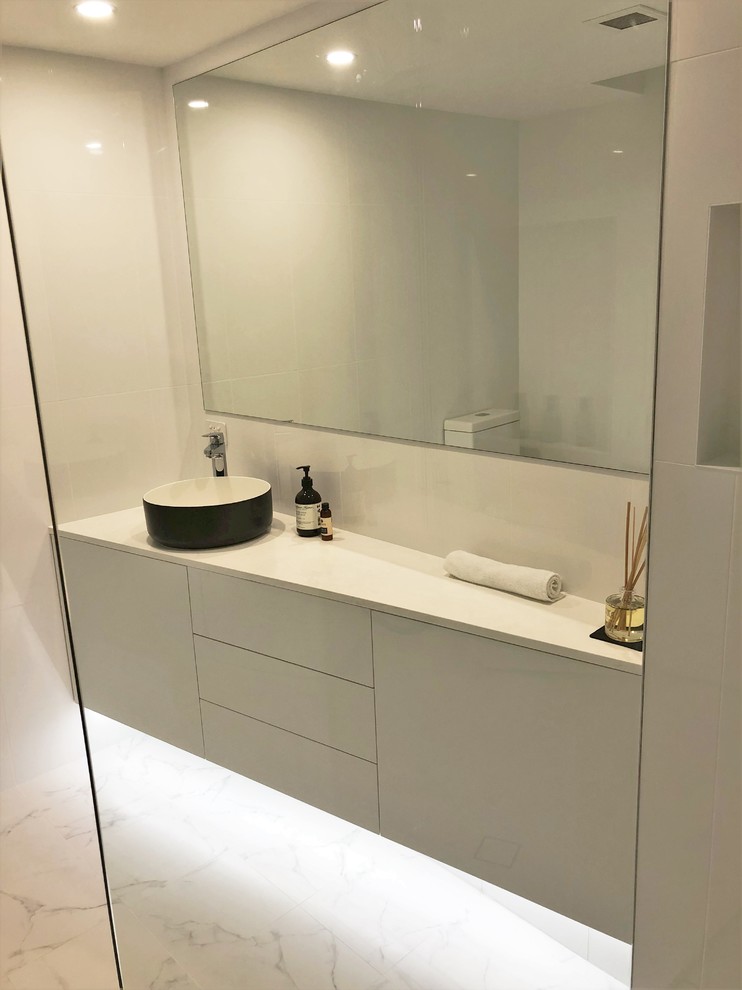 Ejemplo de cuarto de baño flotante y único moderno pequeño con armarios con paneles lisos, baldosas y/o azulejos blancos, baldosas y/o azulejos de cerámica, lavabo sobreencimera y encimera de laminado