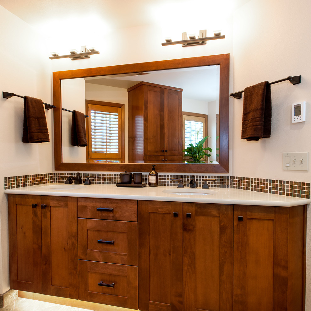 シアトルにある広いトラディショナルスタイルのおしゃれな浴室 (アンダーカウンター洗面器、中間色木目調キャビネット、珪岩の洗面台、茶色いタイル、石タイル、白い壁) の写真