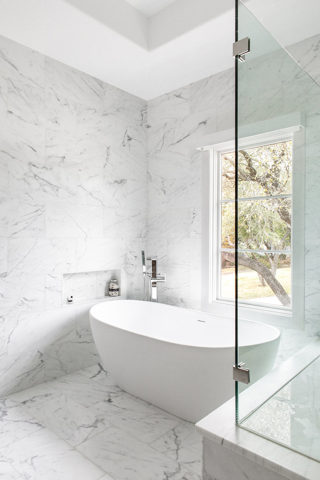 Ispirazione per una stanza da bagno design con vasca freestanding, piastrelle bianche, pareti bianche e pavimento bianco