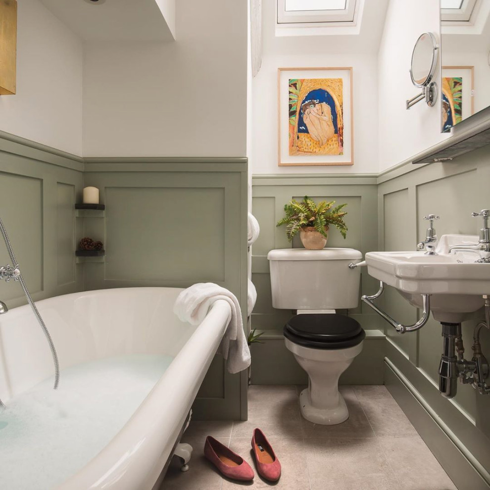 На фото: ванная комната среднего размера в классическом стиле с отдельно стоящей ванной, раздельным унитазом, зелеными стенами, душевой кабиной, подвесной раковиной, серым полом, тумбой под одну раковину и панелями на стенах с