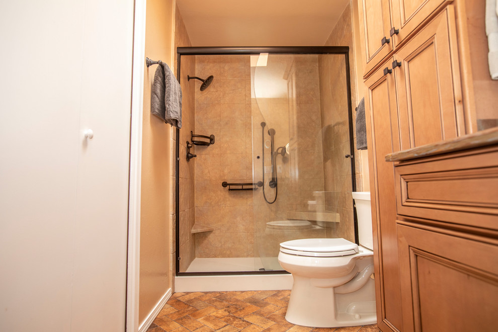 Inspiration för ett litet amerikanskt en-suite badrum, med luckor med infälld panel, skåp i ljust trä, en dusch i en alkov, en toalettstol med hel cisternkåpa, beige kakel, klinkergolv i keramik, ett integrerad handfat, flerfärgat golv och dusch med skjutdörr