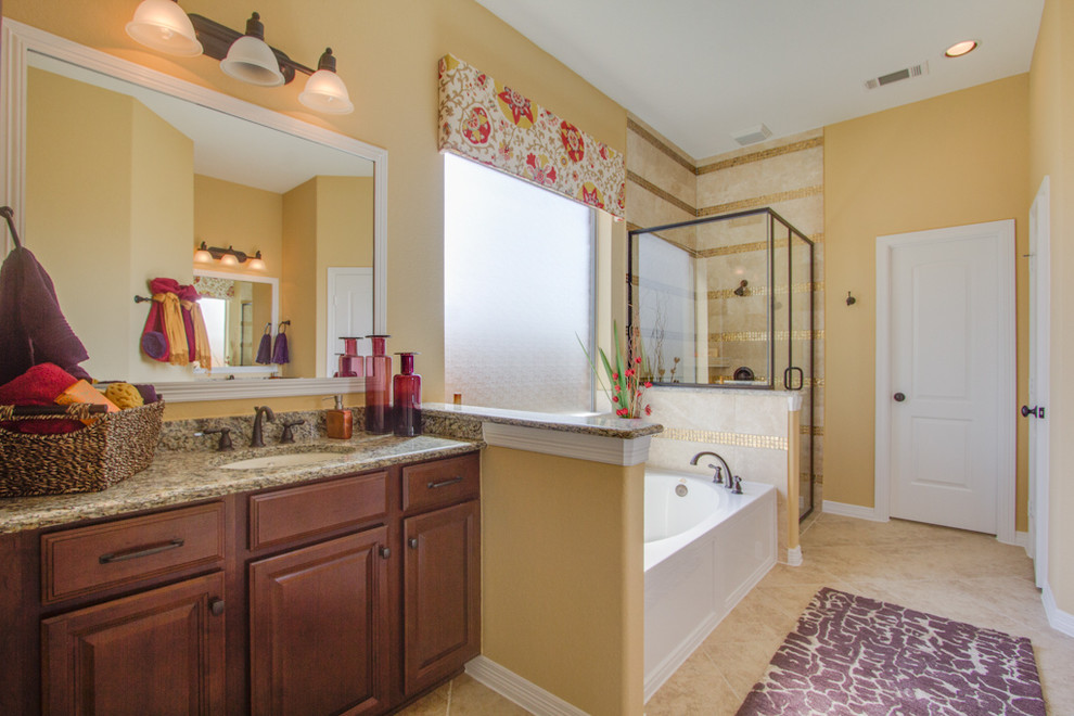Пример оригинального дизайна: главная ванная комната в классическом стиле с фасадами в стиле шейкер, коричневыми фасадами, полом из керамической плитки, бежевым полом, коричневой столешницей, столешницей из гранита, накладной ванной, угловым душем, бежевой плиткой, керамической плиткой, желтыми стенами, врезной раковиной и душем с распашными дверями