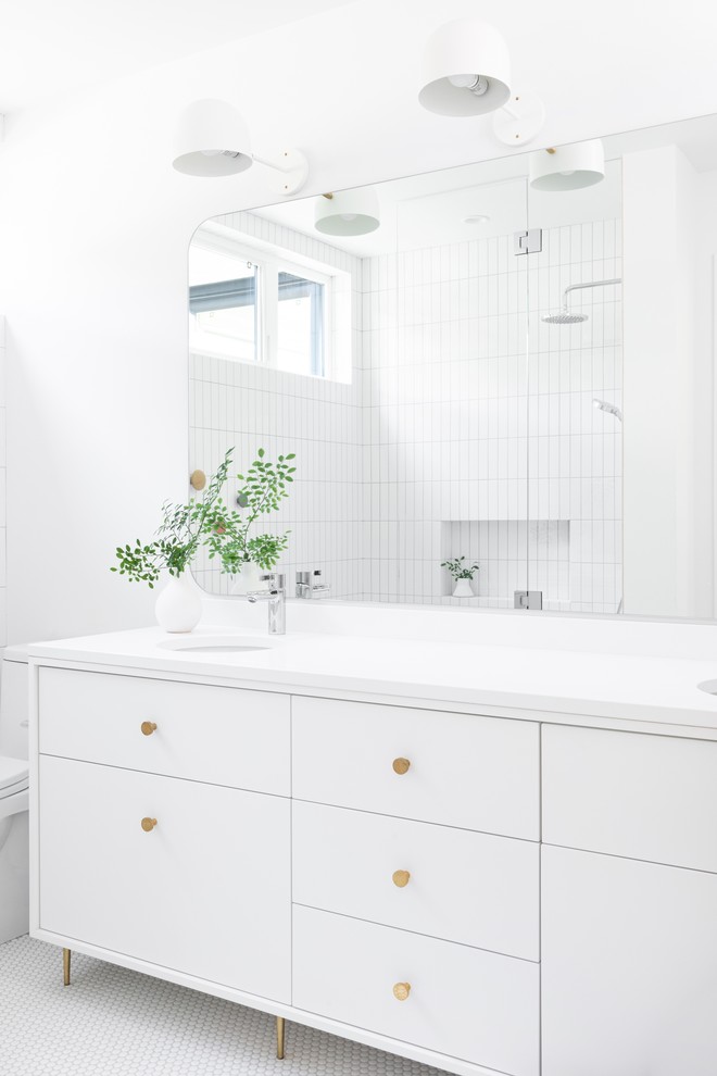 Пример оригинального дизайна: ванная комната в скандинавском стиле с белыми фасадами, белой плиткой, белыми стенами, полом из мозаичной плитки, врезной раковиной, белым полом, белой столешницей и плоскими фасадами