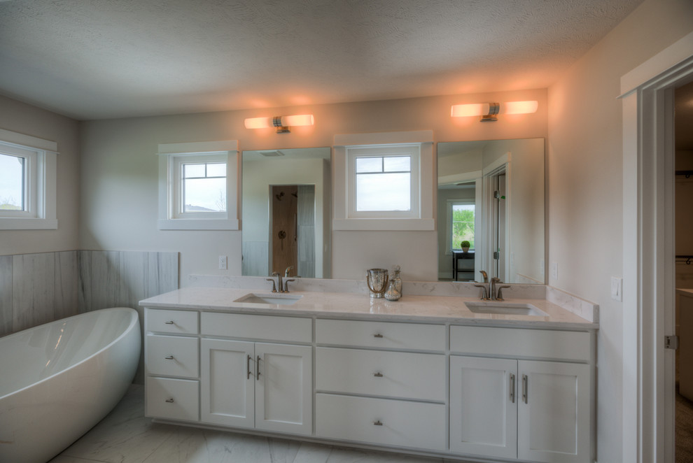 Foto de cuarto de baño principal grande con puertas de armario blancas, bañera exenta y ducha abierta