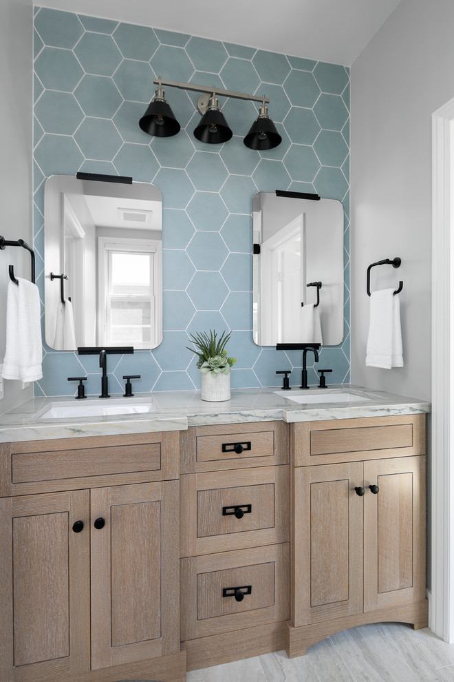 На фото: ванная комната в морском стиле с светлыми деревянными фасадами, синей плиткой, серыми стенами, врезной раковиной, серым полом, серой столешницей, зеркалом с подсветкой и фасадами в стиле шейкер