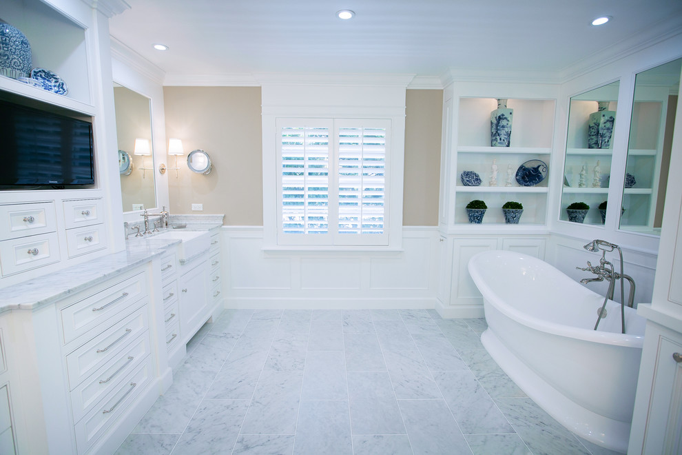Design ideas for a large traditional ensuite bathroom in Orange County with beaded cabinets, white cabinets, marble worktops, a freestanding bath, white tiles, beige walls and marble flooring.
