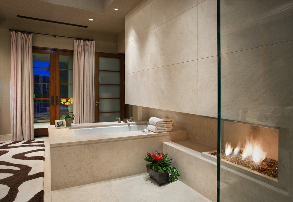 Immagine di un'ampia stanza da bagno padronale design con vasca sottopiano, piastrelle beige, pareti beige, pavimento in pietra calcarea, piastrelle di pietra calcarea e pavimento beige
