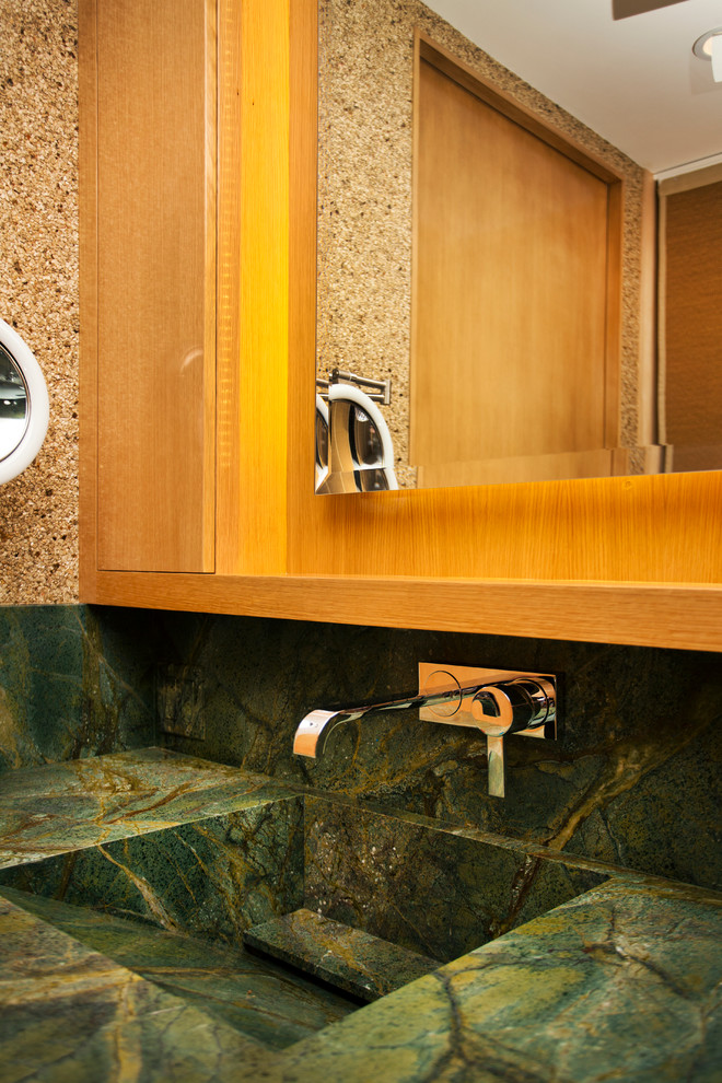 Exemple d'une petite salle d'eau tendance en bois clair avec un lavabo intégré, un placard à porte plane, un plan de toilette en granite, un mur beige et un plan de toilette vert.