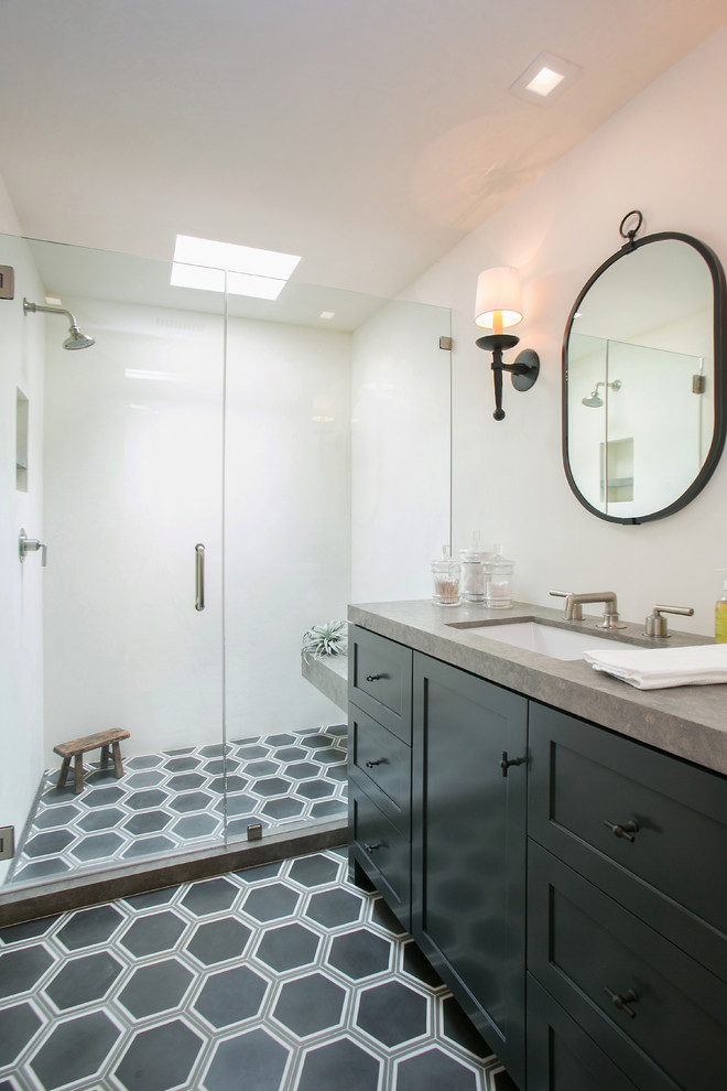 Classic bathroom in Orange County with shaker cabinets, black cabinets, an alcove shower, white walls, a submerged sink, grey floors, a hinged door and grey worktops.