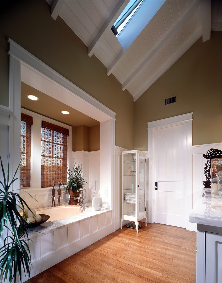 Foto de cuarto de baño clásico con lavabo bajoencimera, puertas de armario blancas y bañera encastrada sin remate
