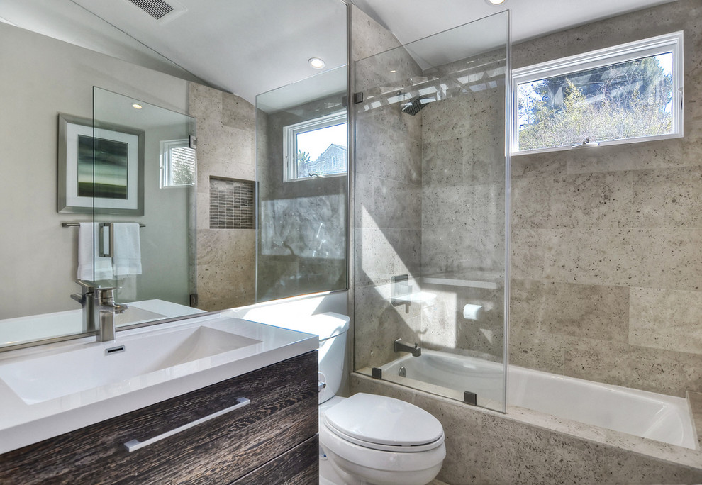 Mittelgroßes Modernes Badezimmer mit integriertem Waschbecken, flächenbündigen Schrankfronten, dunklen Holzschränken, Badewanne in Nische, Duschnische, Wandtoilette mit Spülkasten, grauen Fliesen und grauer Wandfarbe in Orange County