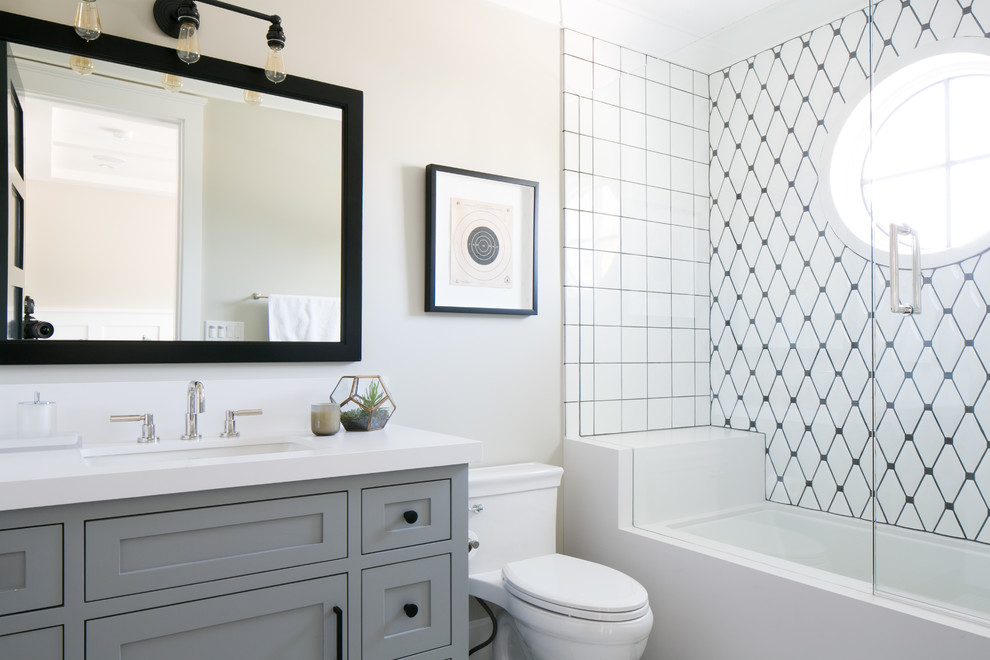Imagen de cuarto de baño gris y blanco clásico renovado con armarios estilo shaker, puertas de armario grises, paredes beige, sanitario de una pieza y baldosas y/o azulejos blancos