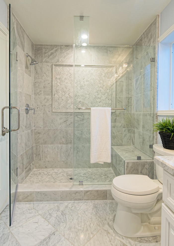 Ejemplo de cuarto de baño costero con puertas de armario blancas, encimera de mármol y baldosas y/o azulejos grises