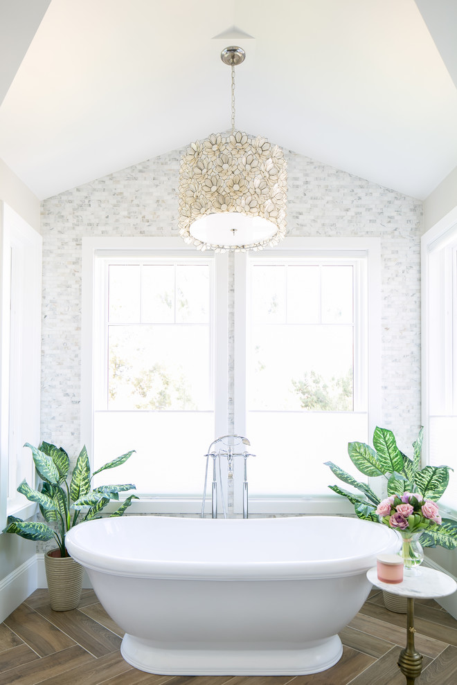Diseño de cuarto de baño tradicional renovado con bañera exenta, baldosas y/o azulejos grises, baldosas y/o azulejos blancos, baldosas y/o azulejos en mosaico, paredes blancas y suelo marrón