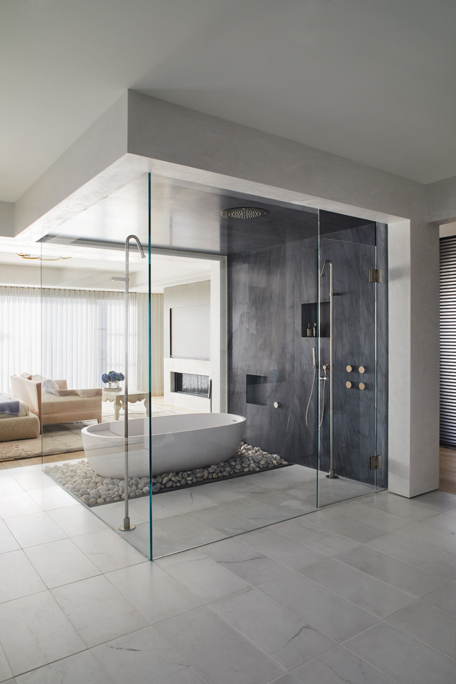 Immagine di una stanza da bagno contemporanea con vasca freestanding, doccia a filo pavimento, piastrelle grigie, pavimento beige e porta doccia a battente