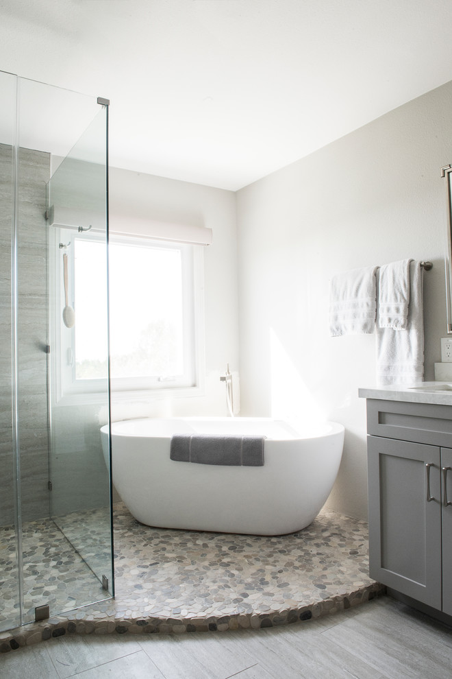 Inspiration för små moderna en-suite badrum, med skåp i shakerstil, grå skåp, ett fristående badkar, en dusch/badkar-kombination, grå väggar, ljust trägolv, grått golv och dusch med gångjärnsdörr