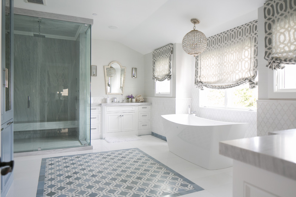 Идея дизайна: серо-белая ванная комната в стиле неоклассика (современная классика) с фасадами с декоративным кантом, белыми фасадами, мраморной столешницей, отдельно стоящей ванной, угловым душем, белой плиткой и белыми стенами