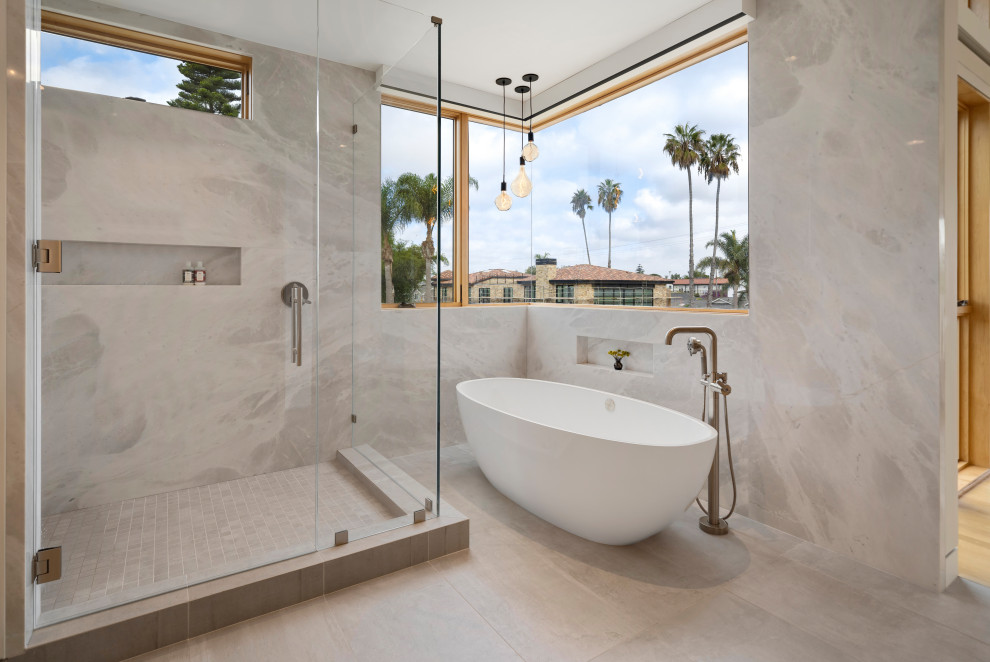 Idées déco pour une grande salle de bain principale contemporaine en bois clair avec un placard à porte plane, une baignoire indépendante, un carrelage gris, des dalles de pierre et un plan de toilette blanc.