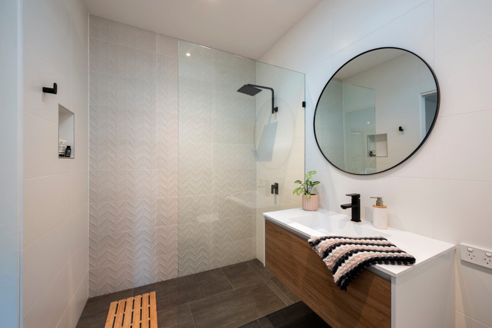 Example of a small trendy white tile and porcelain tile single-sink bathroom design in Melbourne with light wood cabinets, a two-piece toilet, an integrated sink, white countertops and a floating vanity