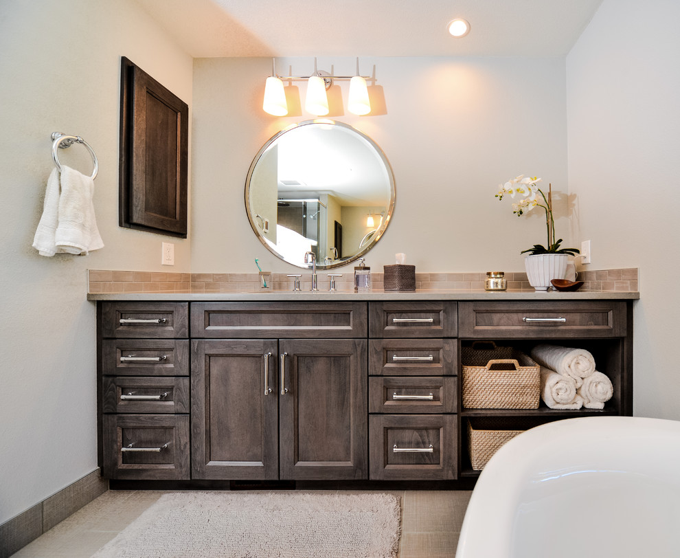Traditional bathroom in Seattle with recessed-panel cabinets, dark wood cabinets, a freestanding bath, white walls, a submerged sink, beige floors and beige worktops.