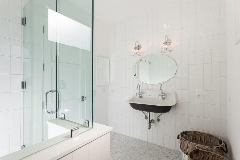 Cette photo montre une salle de bain bord de mer avec un lavabo suspendu, un mur blanc, un sol en marbre et un carrelage blanc.