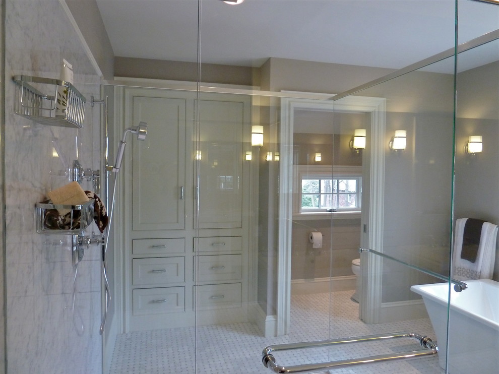 На фото: большая главная ванная комната в стиле фьюжн с фасадами в стиле шейкер, белыми фасадами, отдельно стоящей ванной, открытым душем, раздельным унитазом, серой плиткой, каменной плиткой, коричневыми стенами и полом из мозаичной плитки с