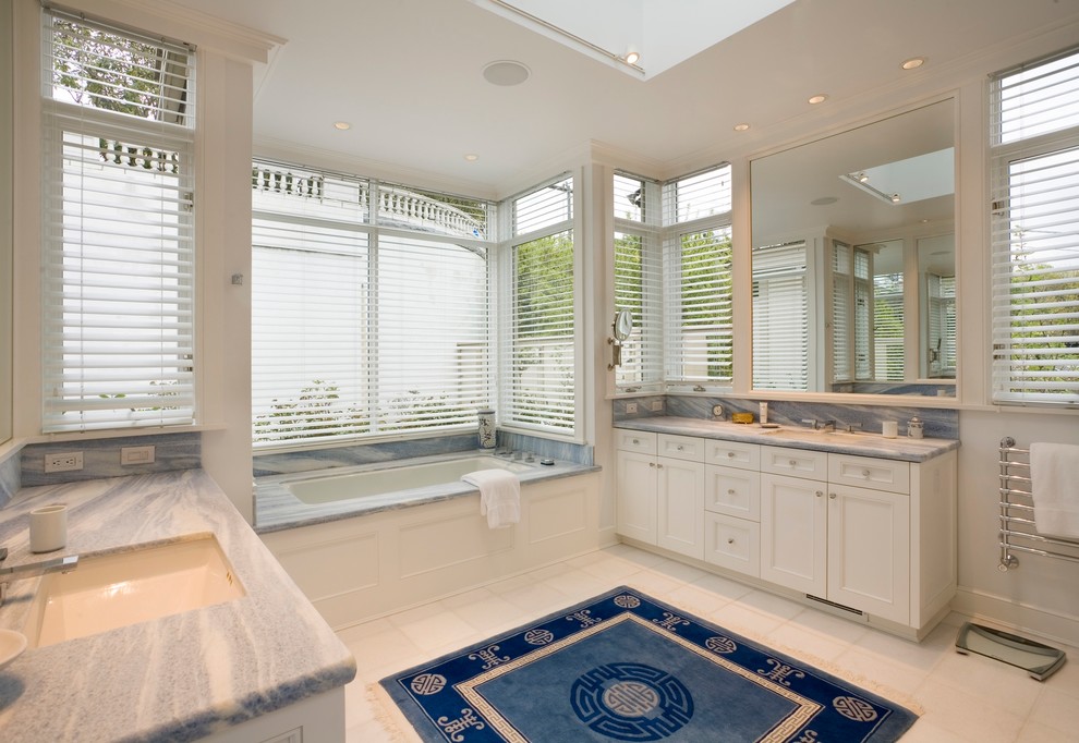 Example of a classic white tile bathroom design in Seattle with an undermount sink, recessed-panel cabinets, white cabinets and an undermount tub