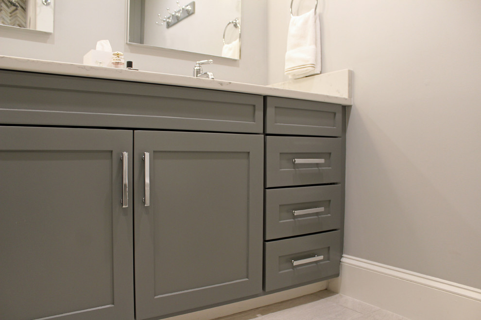 Small traditional family bathroom in Boston with recessed-panel cabinets, grey cabinets, an alcove shower, a two-piece toilet, grey tiles, porcelain tiles, grey walls, porcelain flooring, a submerged sink, engineered stone worktops, grey floors, a hinged door and white worktops.