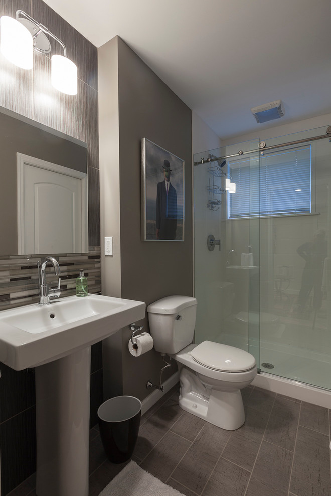 Modern inredning av ett litet badrum, med en dusch i en alkov, en toalettstol med separat cisternkåpa, vit kakel, keramikplattor, grå väggar, klinkergolv i porslin, ett piedestal handfat, grått golv och dusch med skjutdörr