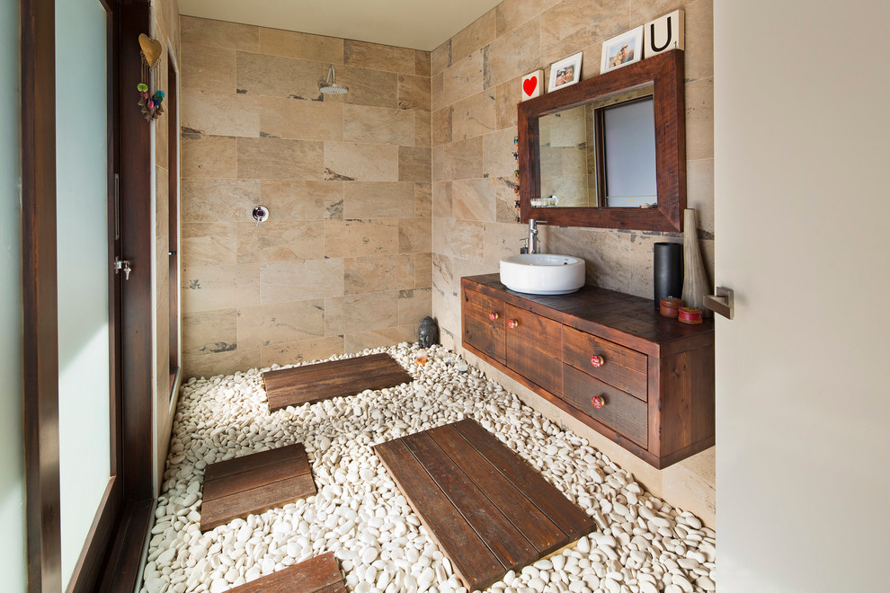 Modernes Badezimmer mit Aufsatzwaschbecken, flächenbündigen Schrankfronten, dunklen Holzschränken, Waschtisch aus Holz, offener Dusche, beigen Fliesen, offener Dusche, brauner Waschtischplatte und Steinwänden in Sydney
