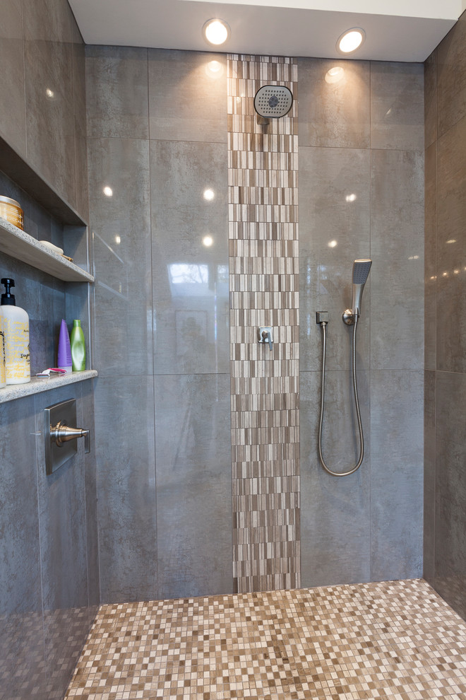 Example of a large minimalist master gray tile and porcelain tile travertine floor and gray floor bathroom design in New York with flat-panel cabinets, brown cabinets, a two-piece toilet, gray walls, an undermount sink, recycled glass countertops and a hinged shower door