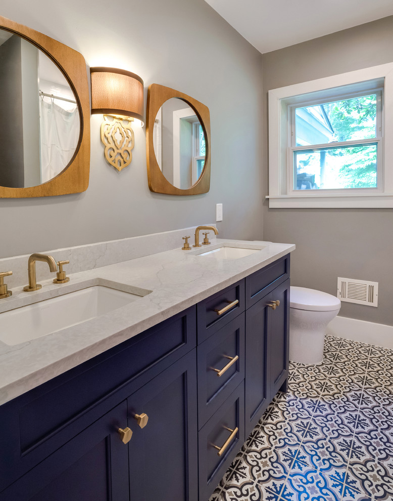Foto di una stanza da bagno moderna con ante blu, piastrelle grigie e top in quarzite